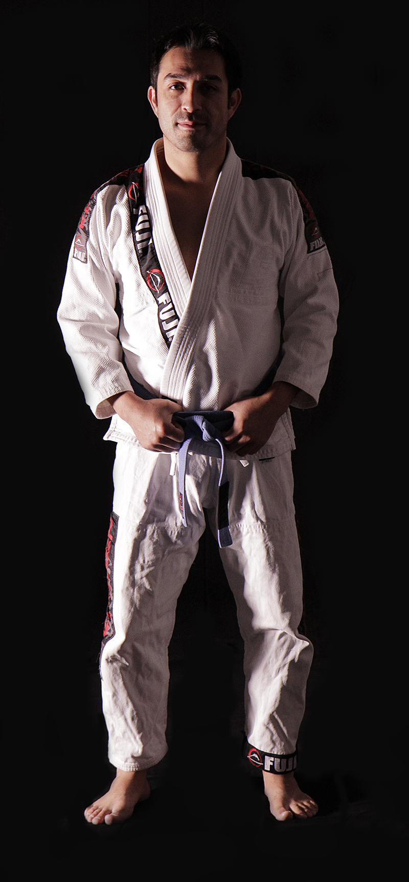 a man in white karate garb standing with his hands on his belt