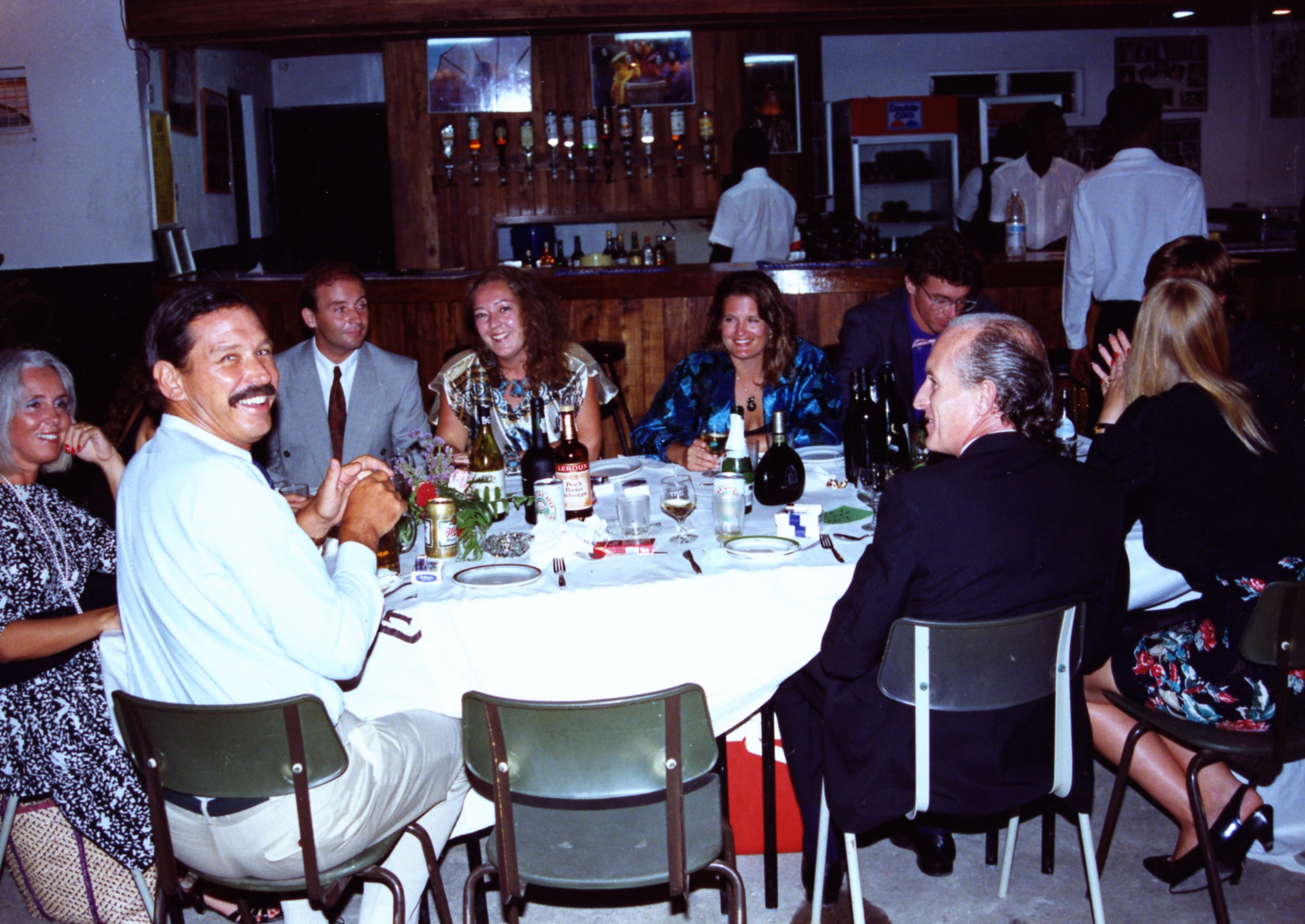 several people sitting around a table having wine