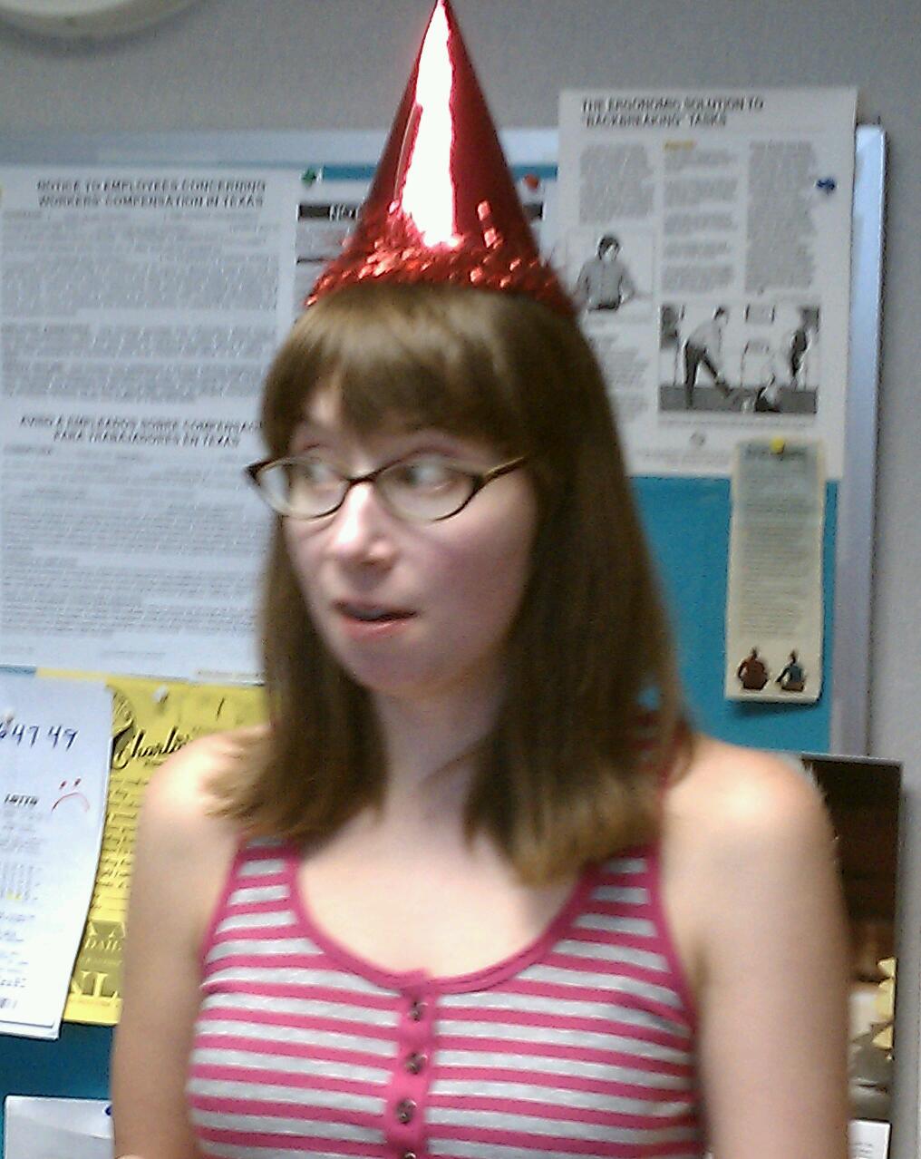 a person with a party hat on and cake