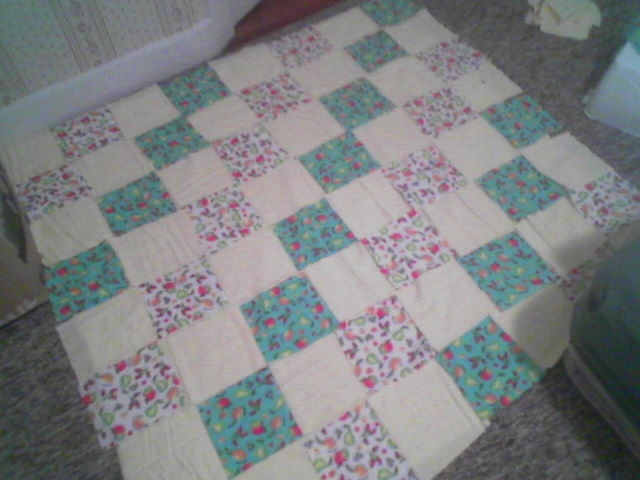 a bed with a floral quilt on the bottom half