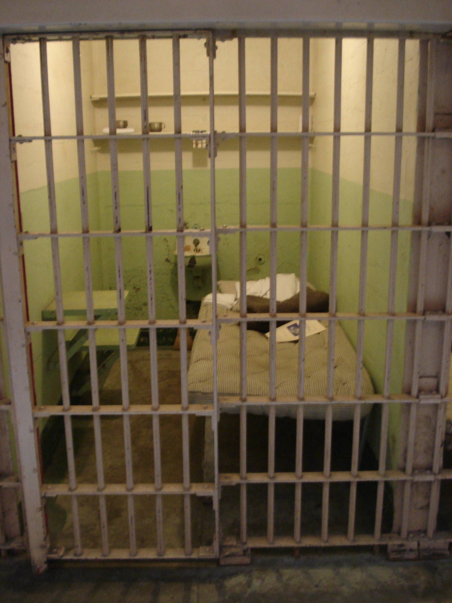 some prison bars are in an area with bedding