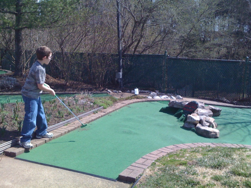 a  standing on a miniature golf course