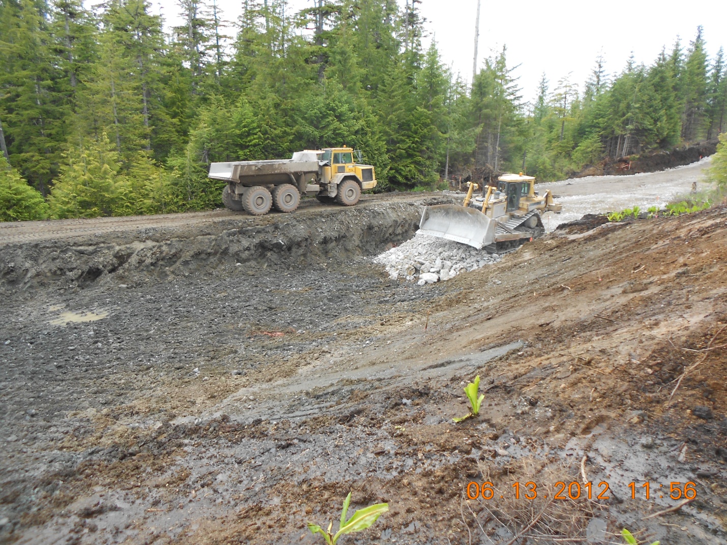 trucks are seen going through the mud and water in a stream