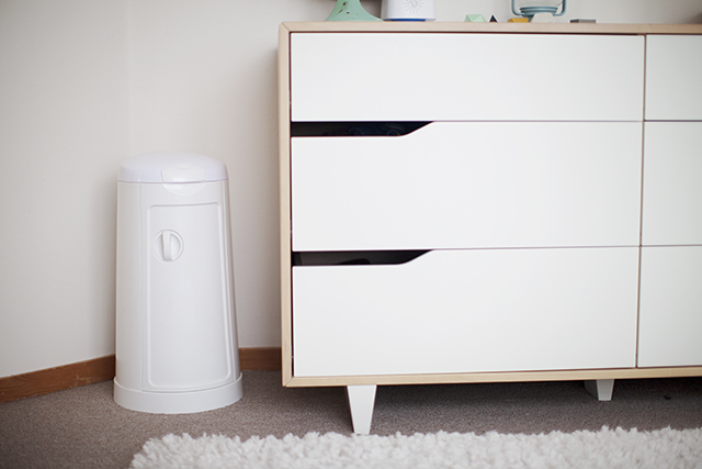 an all white dresser with black drawers in the corner