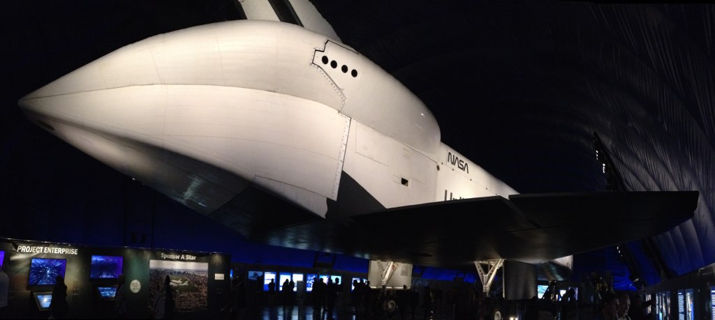 the huge airplane is sitting on display inside of a museum