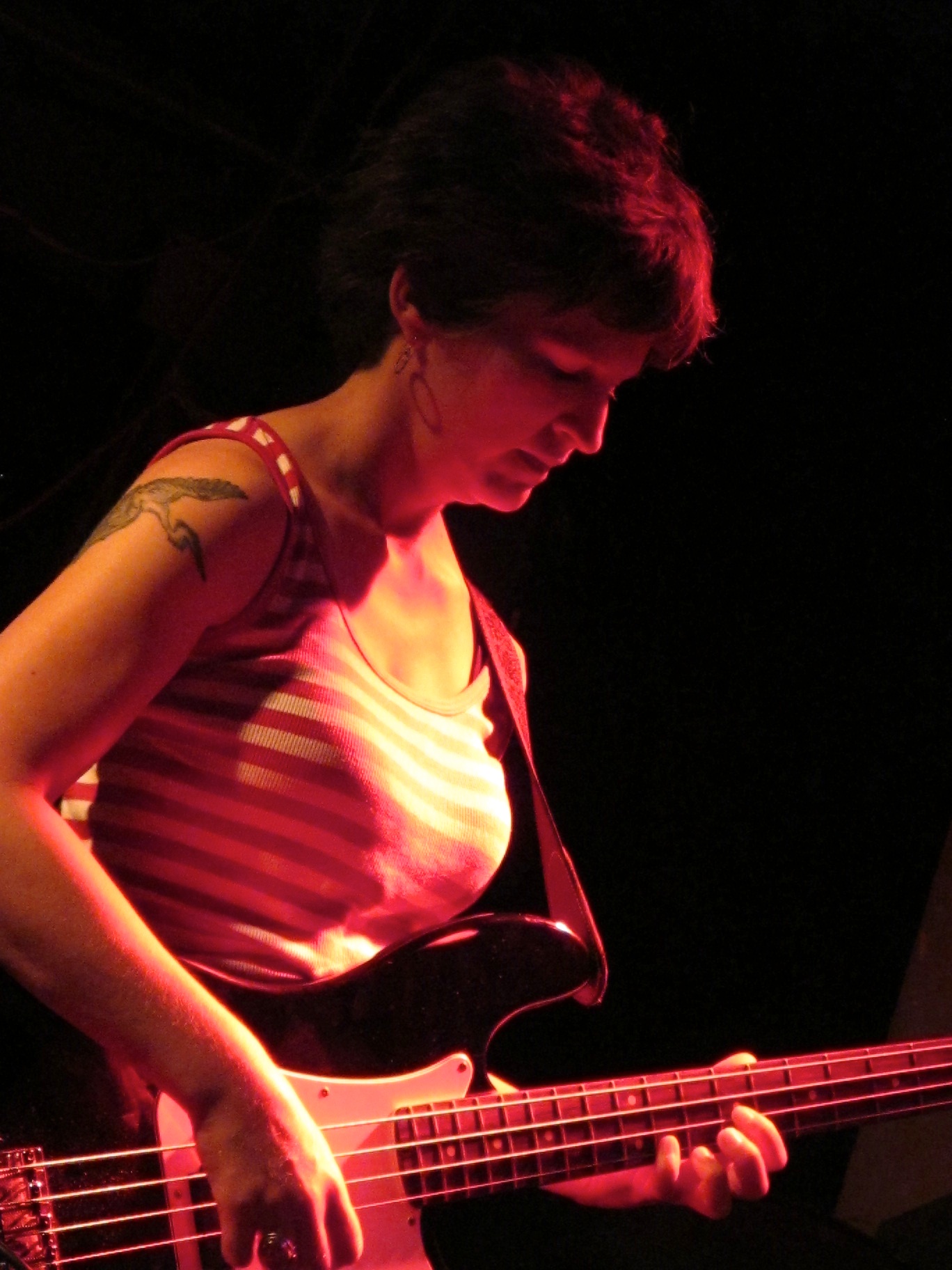 a woman playing an electric guitar in the dark