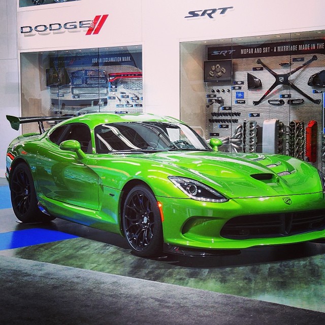 a green sports car sitting in front of a display case