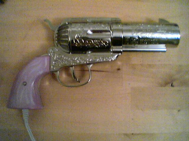 a silver revolver with a pink gun rest on top of the floor