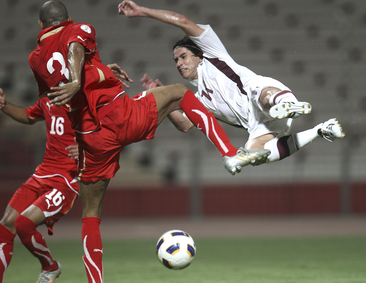 a soccer player attempts to kick the ball