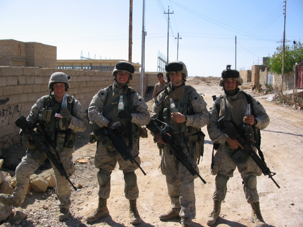 the group of soldiers is standing on the side of the road