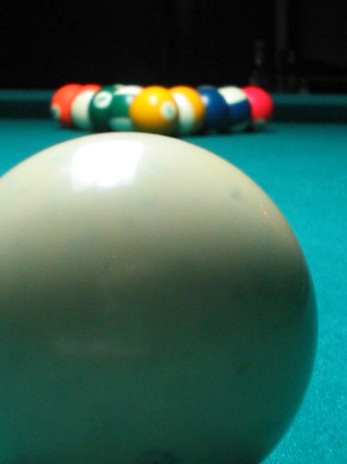 some colorful pool balls on a blue pool table