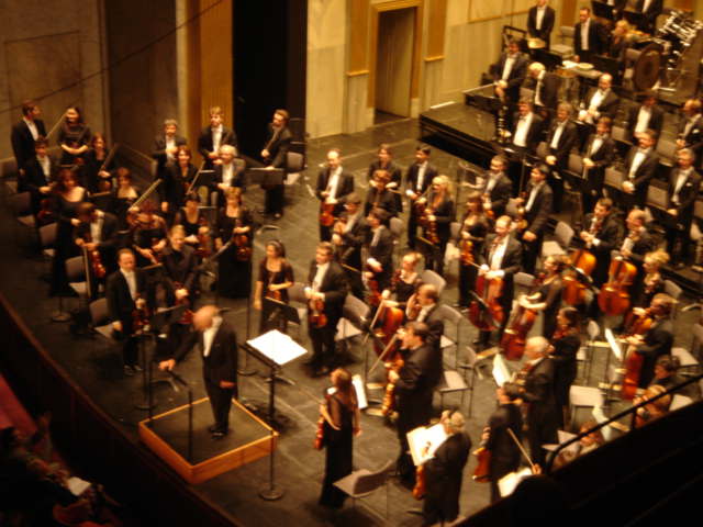 a musical concert with musicians performing in large hall