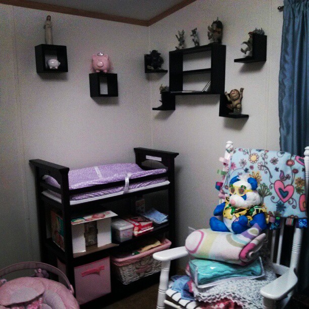 a nursery with several toys in it, and a shelf holding baby items