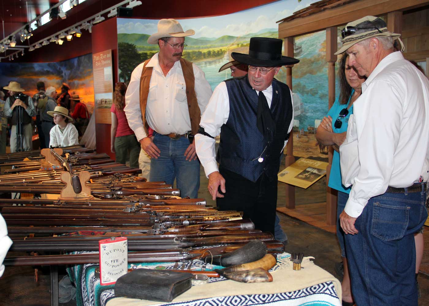 men in cowboy hats look at wooden objects
