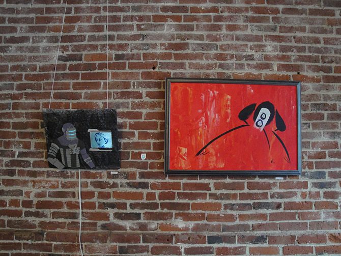 two red paintings on a brick wall of some sort