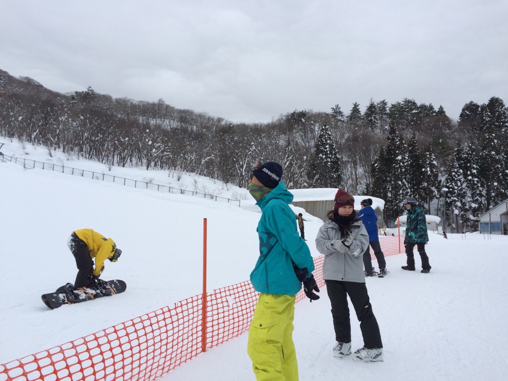 a couple of people riding down a snow covered slope