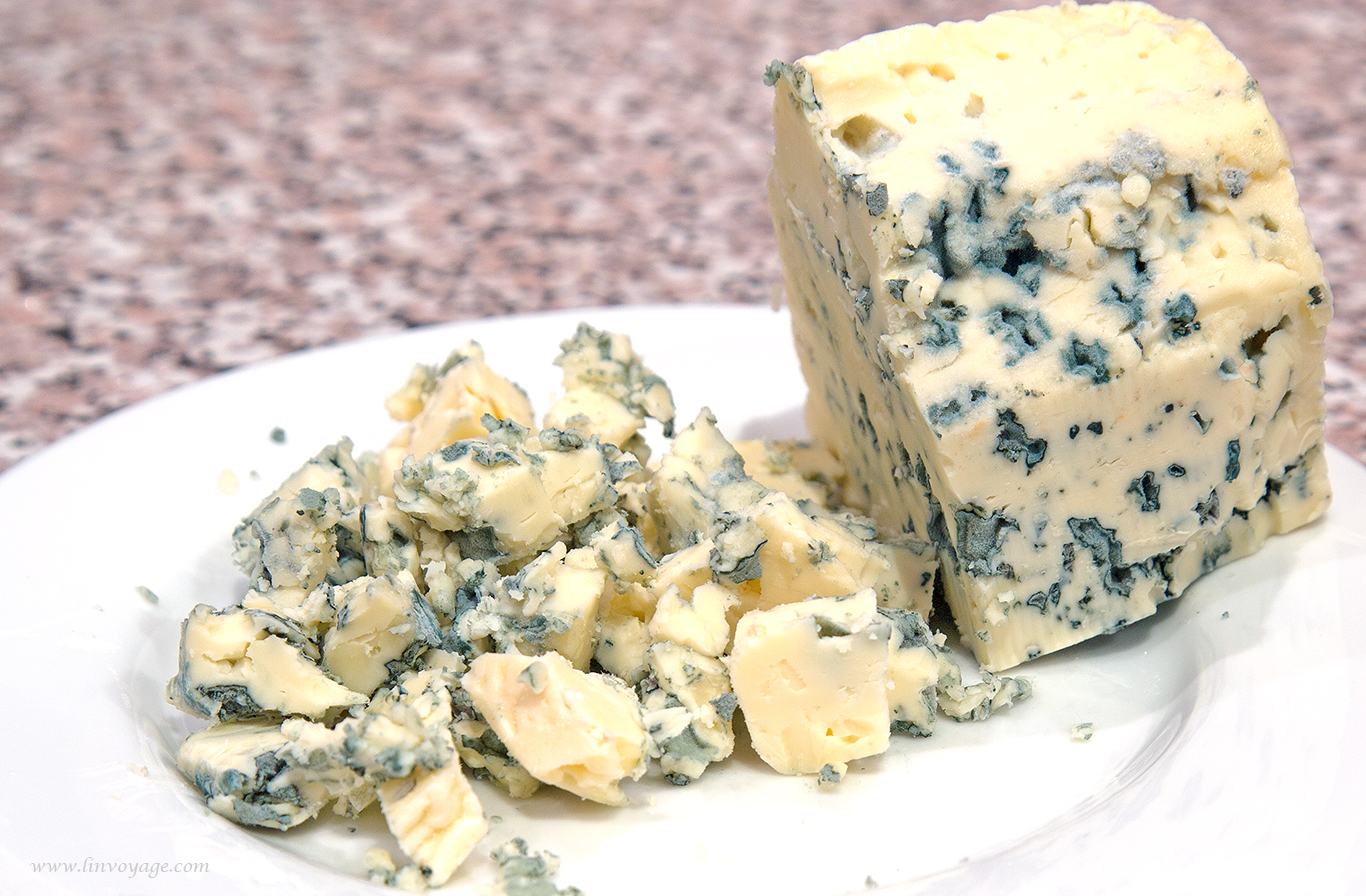 blue cheese and other foods sit on a plate