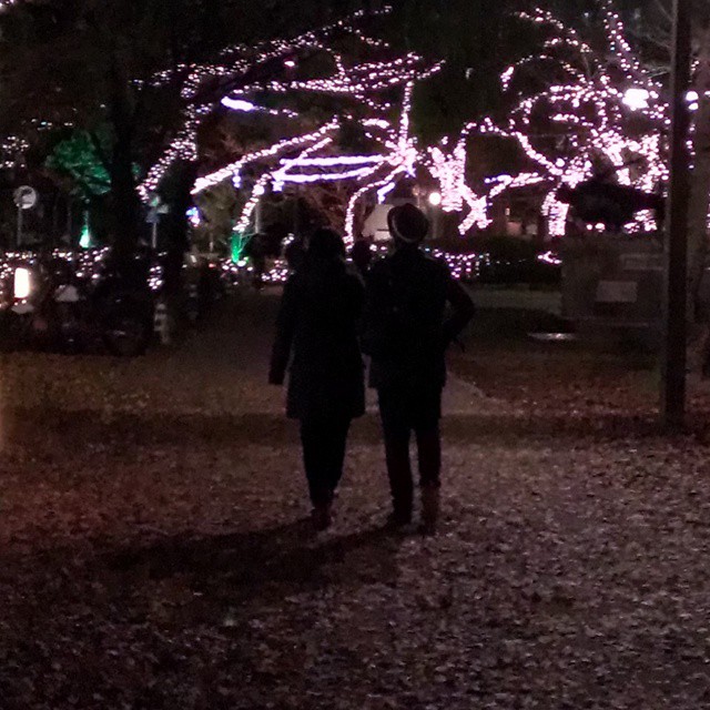 two people walking in the night with lights on