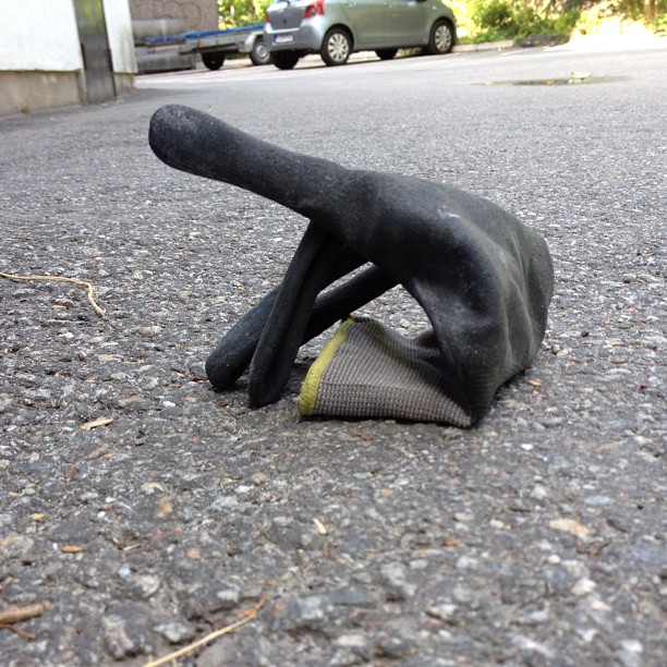 a black sculpture lying on the ground next to a street