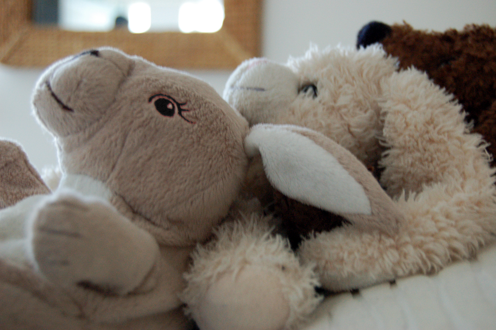 a group of stuffed animals sitting on a bed