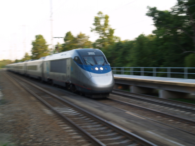 a high speed train with several trees in the background