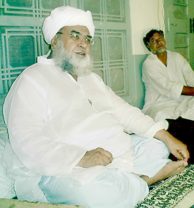 two men sitting in a room wearing white clothes
