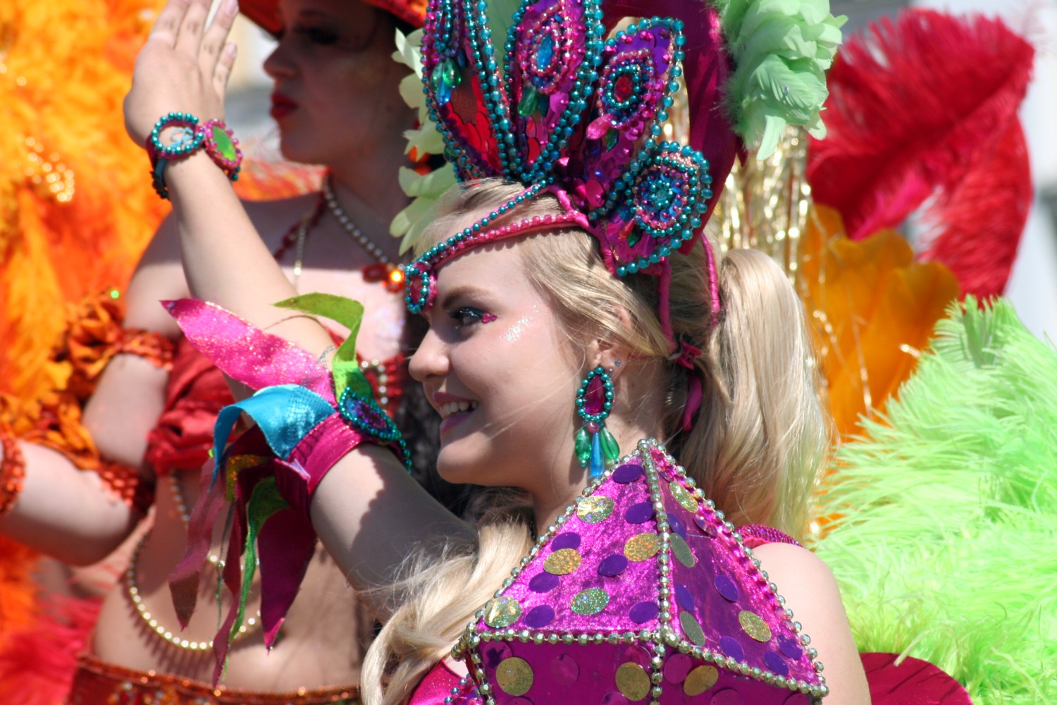 women in colorful costumes waving at the camera