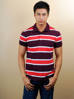 a man wearing a striped shirt and jeans standing