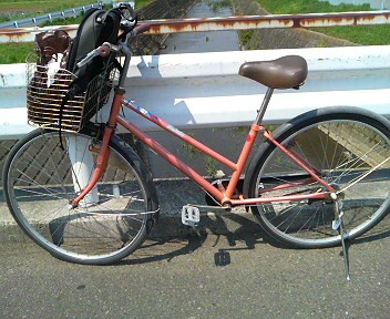 an orange bike with a basket on the back