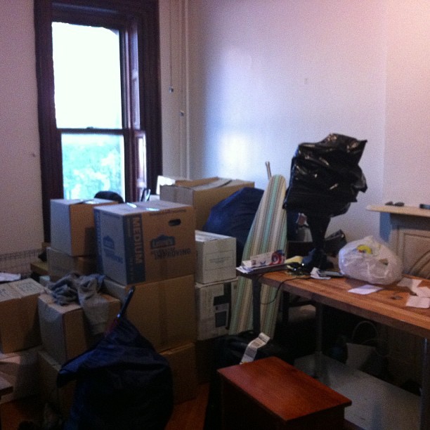 a messy living room is being packed up with boxes, and other belongings