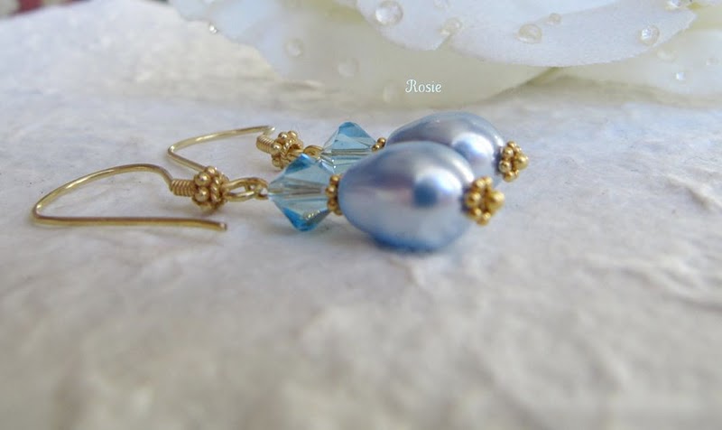two pairs of blue earrings on a white cloth