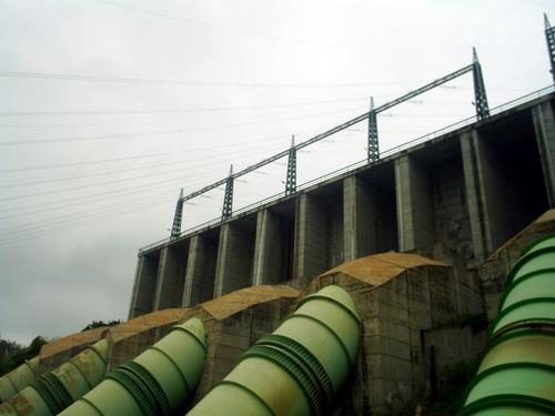 a large long green pipe at the top of a bridge