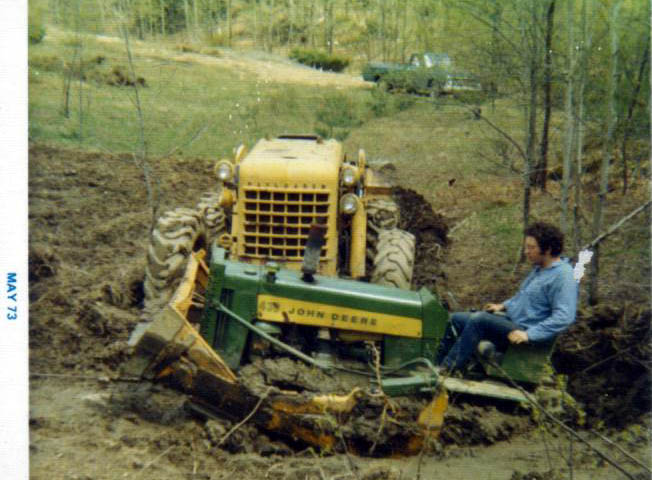 a tractor plows land as it stands behind an older tractor