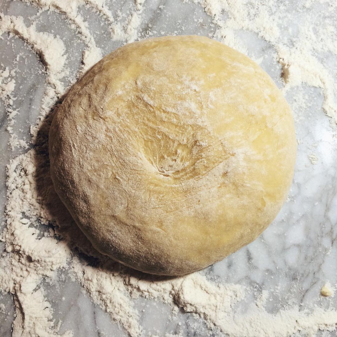 a round dough is sitting on a stone counter