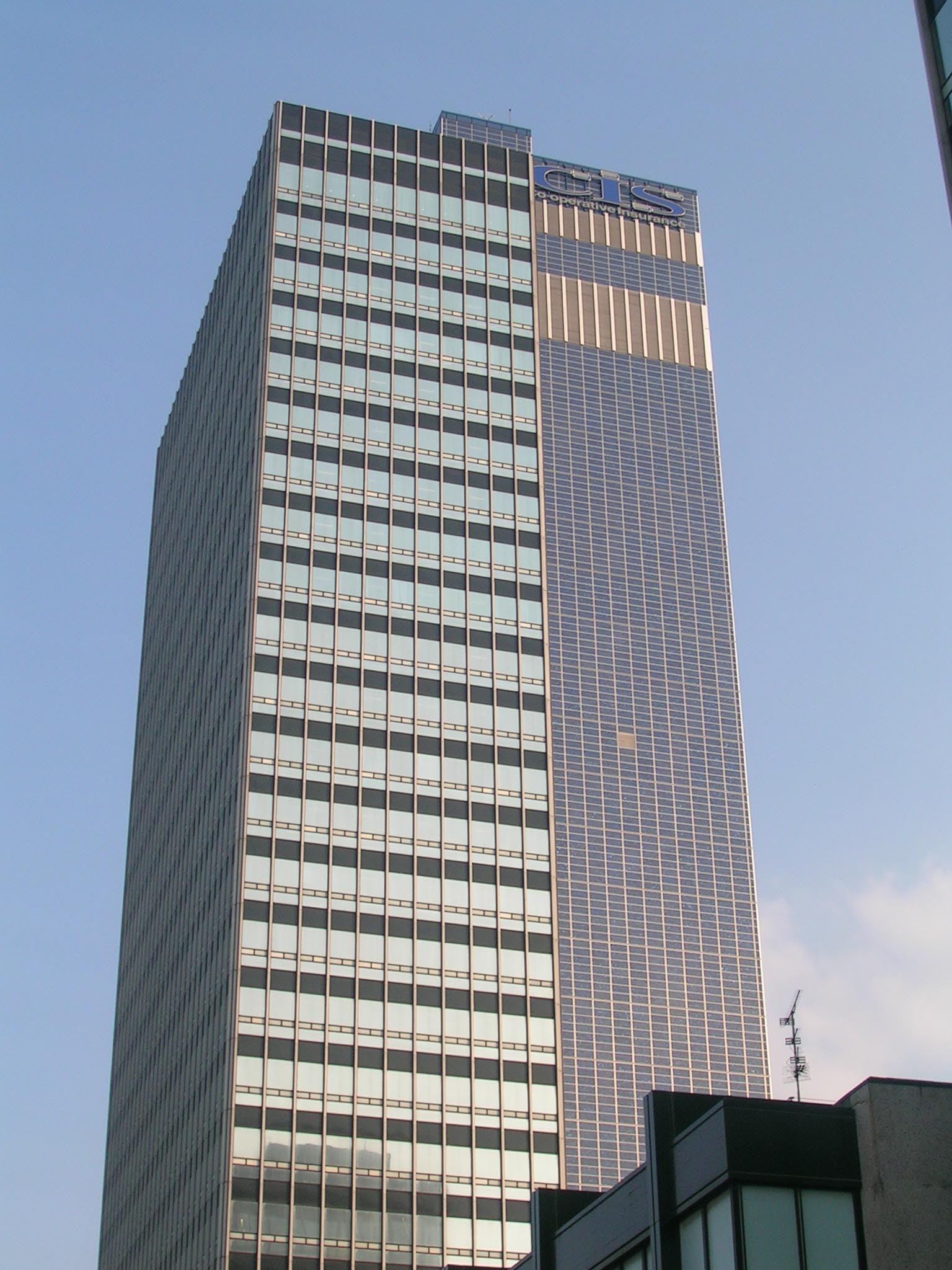 two skyscrs with windows are seen against a blue sky