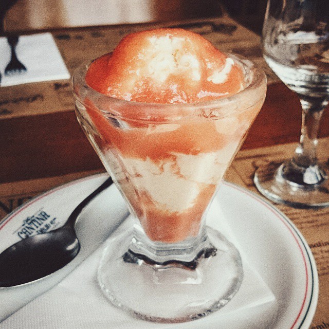 a bowl of dessert on a plate on a wooden table