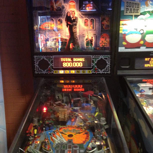 two pinball machines with a woman surrounded by other machines