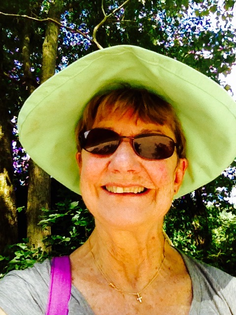 an older lady in a large green hat and sunglasses