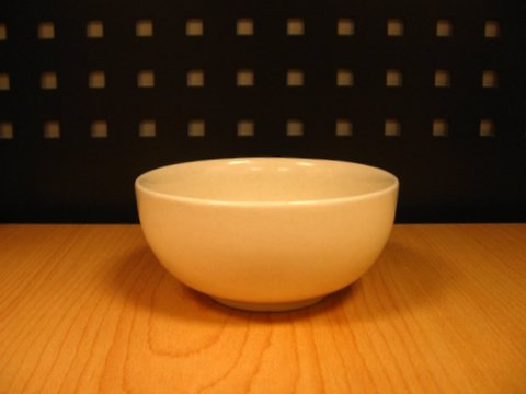 a white bowl sitting on top of a wooden table