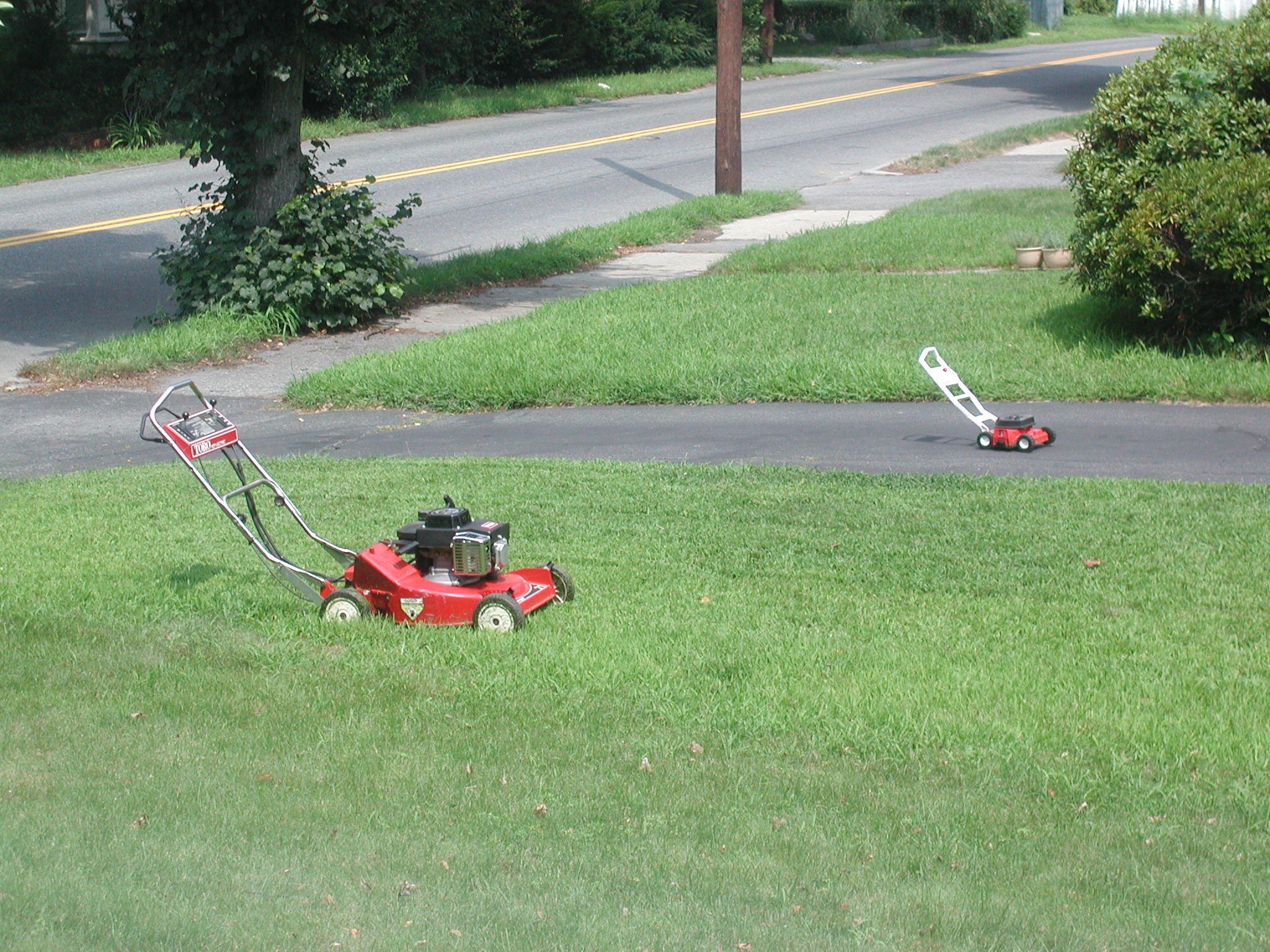 a lawn mower sitting in the middle of a sidewalk