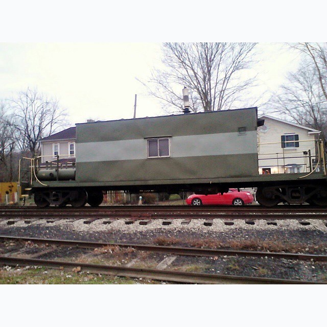 the train is sitting on top of a long box car
