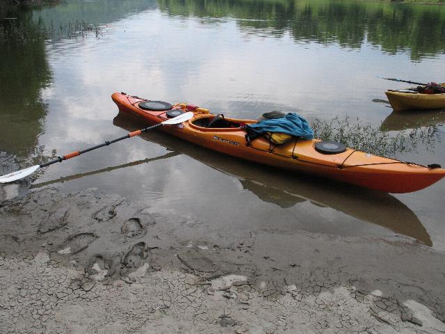 a man with his kayak at the edge of a lake