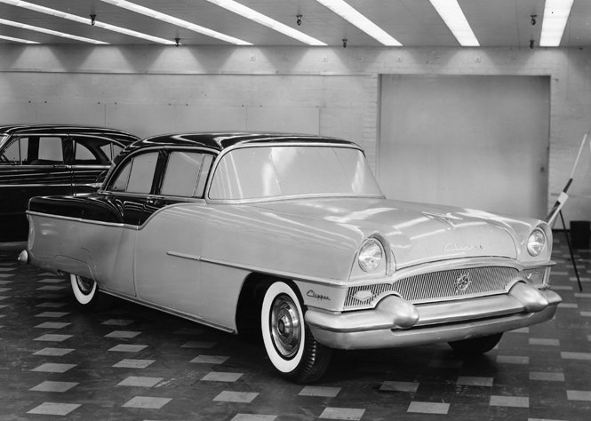 some classic cars in a garage near each other