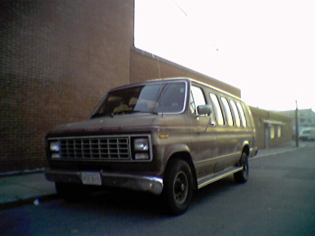 an older model brown van parked on the street