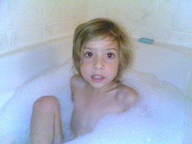 the small child is in the bubble bath