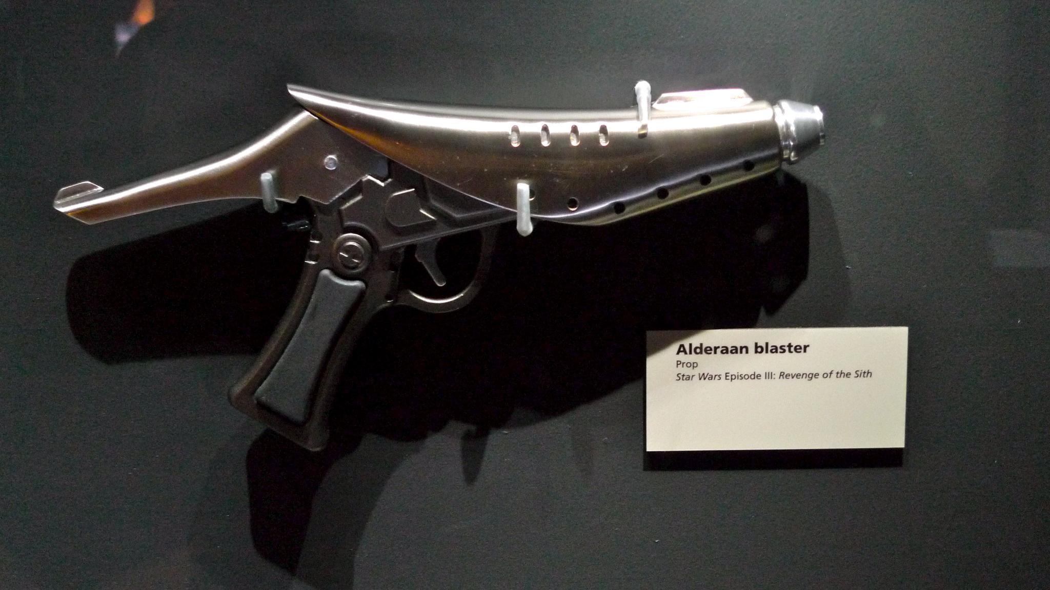 a small gun is mounted in a glass case