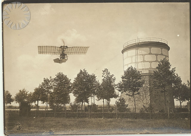 a person flying in an airplane above a tall tower