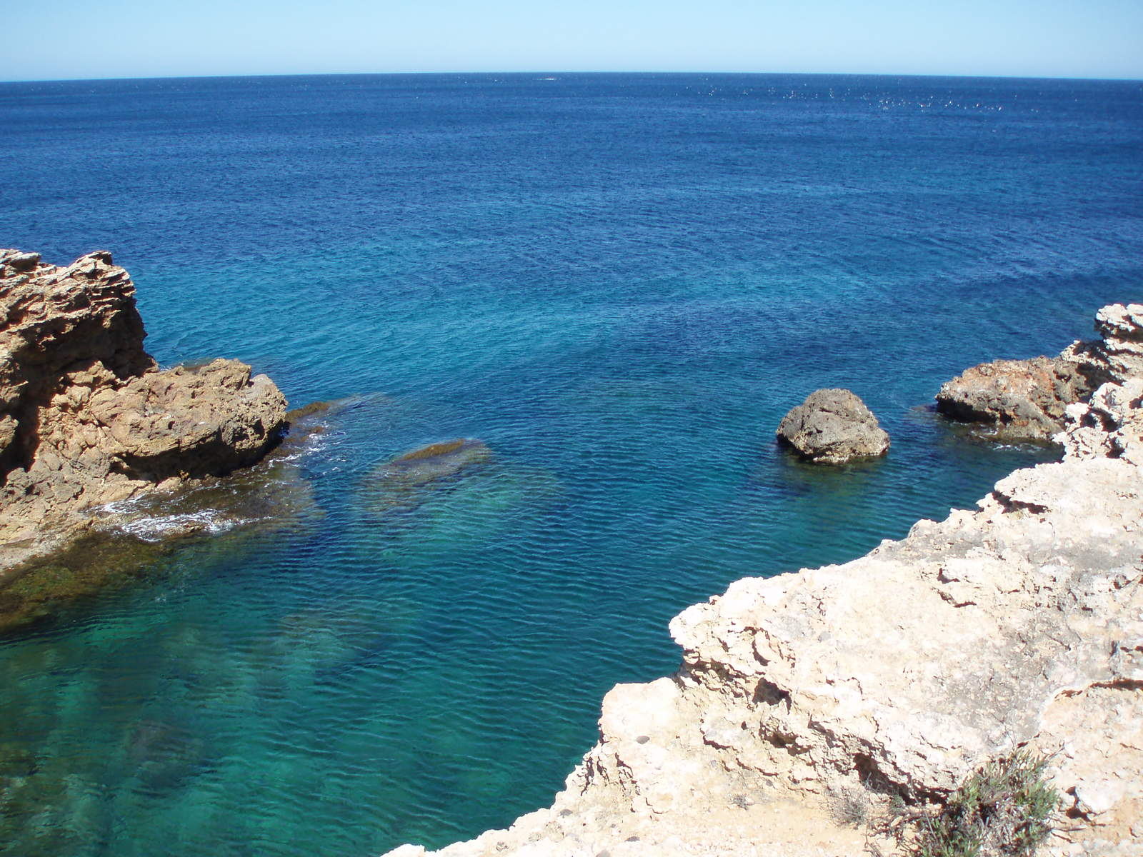 there are rocks sticking out of the blue water