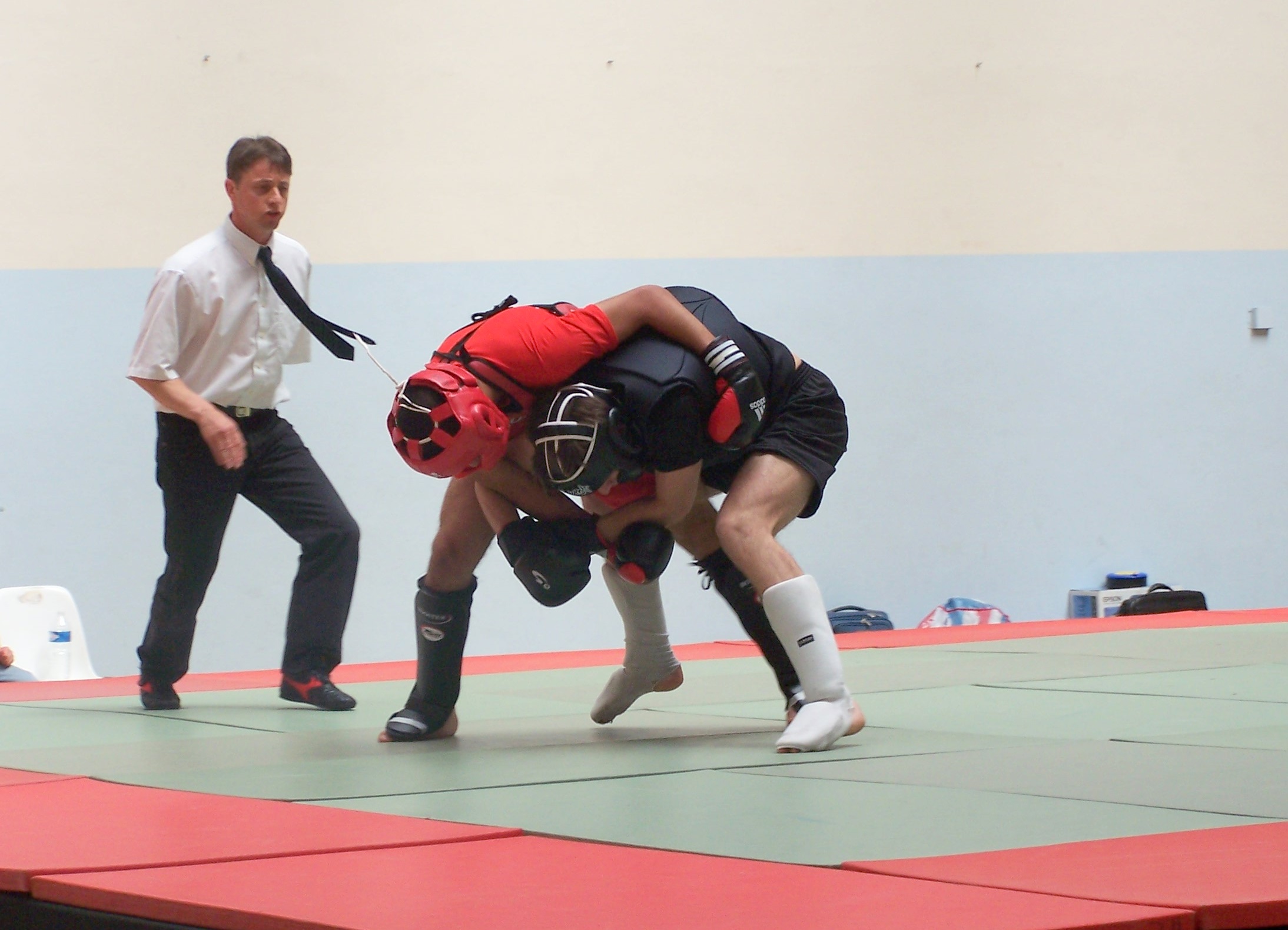 a man standing over another person on a wrestling ring