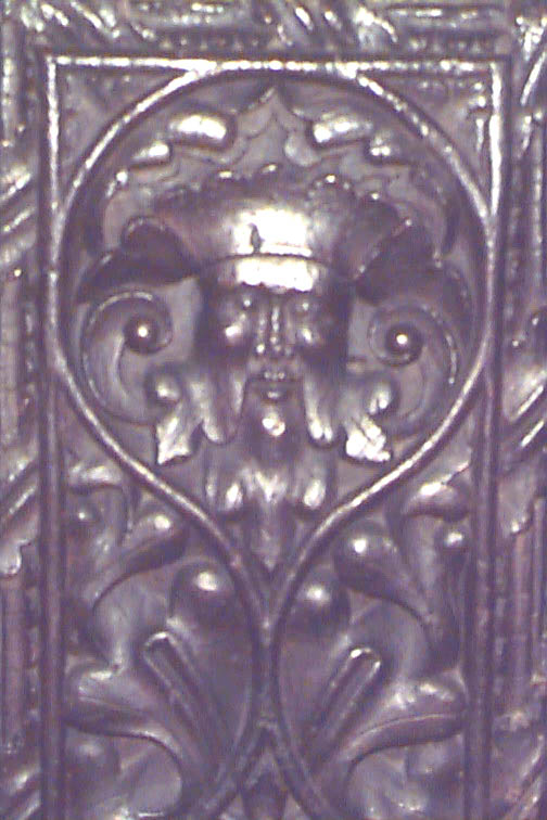 a metal relief showing a lion head with curly hair